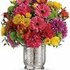 Mixed bouquet of colorful flowers arranged in a vase.