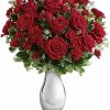 Classic bouquet of red roses with greenery arranged in a clear vase.