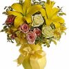 Sunny-yellow flower arrangement with fresh greenery in a vase.