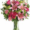 Pink and white flower arrangement with greenery in a vase.