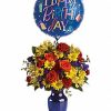 Bold mixed bouquet of vibrant flowers in a clear vase.