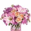 Pink lilies and pastel flowers in clear vase