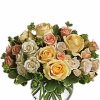 Peach and yellow roses in a bubble bowl vase