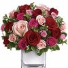 Classic bouquet of red roses with greenery in a clear vase.