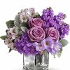 Lavender and purple roses in a glass vase