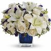 Blue and white bouquet of lilies and delphinium with greenery.