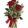 Three red roses with greenery in vase