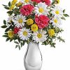 White and yellow daisy bouquet with greenery.
