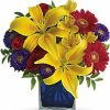 Colorful mixed bouquet displayed in a bold blue glass vase