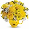 Cheerful bouquet of roses and daisies in a yellow smiley face vase.